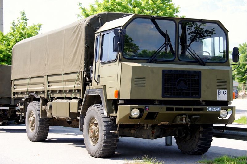 Fahrzeugtyp: Militärischer Lastkraftwagen / Transportfahrzeug
Antrieb: Allradantrieb (4×4 oder 6×6, je nach Ausführung)
Motor: Dieselmotor, luft- oder wassergekühlt
Leistung: typischerweise im Bereich von ca. 180–250 PS
Getriebe: Manuelles Schaltgetriebe mit Geländeuntersetzung
Zulässiges Gesamtgewicht: ca. 10–14 Tonnen
Nutzlast: ca. 4–6 Tonnen
Bereifung: Große Geländereifen mit grobem Profil
Aufbau: Pritsche mit Plane, für Material- oder Truppentransport
Besonderheiten:
hohe Bodenfreiheit
robuste Rahmenkonstruktion
für Einsatz auf Straße und Gelände ausgelegt
Der sichtbare Tarnnetzbesatz und der militärische Aufbau deuten auf eine Nutzung für logistische Aufgaben, nicht für direkte Kampfhandlungen.